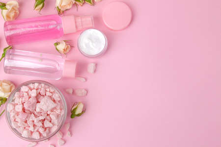 cosmetics for face and body in pink bottles with fresh roses on a delicate pink background. view from above. space for textの写真素材