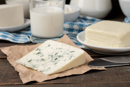 milk products. milk, sour cream, cheese, butter and cottage cheese on a brown wooden table
