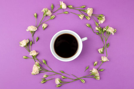 Beautiful mini roses and a cup of coffee on a bright lilac background. holidays. Valentine's Day....