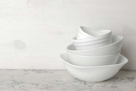 A stack of dishes. tableware on a light concrete background. dishes for serving the table. white bowls in a stack. space for textの写真素材