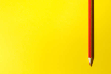 Red pencil on a bright yellow background. Place for text. top viewの写真素材
