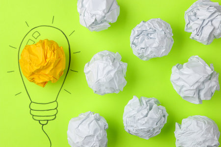 Concept creative idea. concept of creative idea. Crumpled paper balls and painted light bulb on...