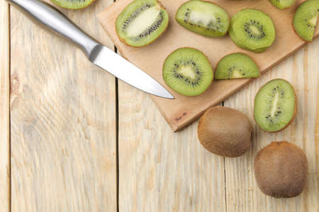 Delicious ripe lots of kiwi fruit and kiwi cutaway cut on a natural wooden table. top view. space for textの写真素材