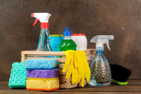 Bottles with cleansers and detergents in a box on a brown background. cleaning. cleaning products.の写真素材