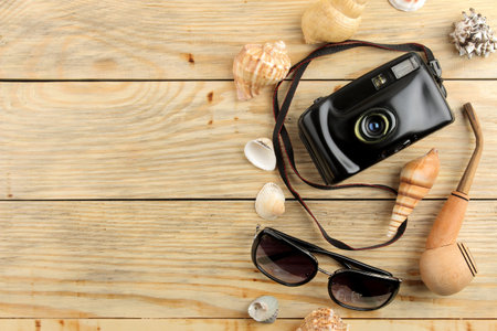 Travel concept Glasses, camera and shells on a natural wooden table. relaxation. holidays. view from...