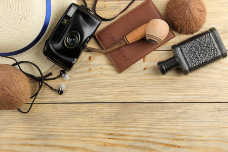 Travel concept Passport, glasses, camera and men's accessories on a natural wooden table....