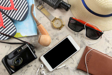 Travel concept Smartphone, passport, map, photo chamber and sunglasses on a light concrete background. top viewの写真素材