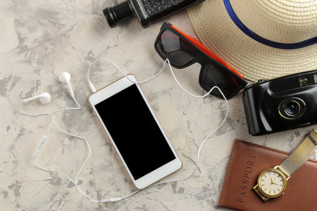 Travel concept Smartphone, passport, map, photo chamber and sunglasses on a light concrete...