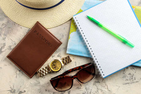 Travel concept hat, passport, map, camera and sunglasses on a light concrete background. top viewの写真素材