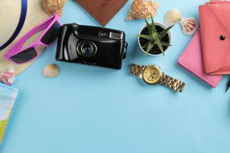 Travel concept. camera passport, hat, card and glasses on a bright blue background. top view.