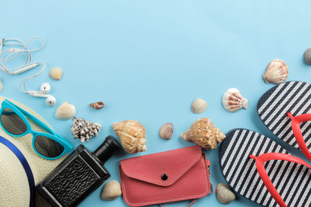 Travel concept. Hat, wallet, flip flops, card and glasses on a bright blue background. top view....