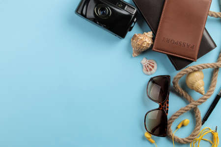Travel concept. Passport, camera, and glasses on a bright blue background. top view. space for textの写真素材