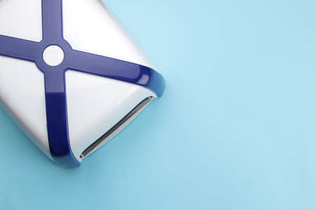 Manicure. UV lamp on a blue trend background. Manicure accessories and tools for nails. top viewの写真素材