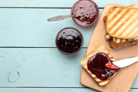 toasts with jam. fried crispy toast with red jam on a blue wooden table. breakfast. top view