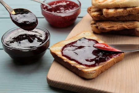 toasts with jam. fried crispy toast with red jam on a blue wooden table. breakfast.の写真素材