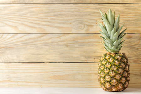 Ripe pineapple fruit on natural wooden background. summer. space for textの写真素材