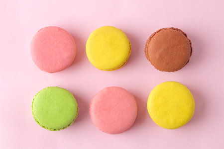 Macarons french multicolored macaroons cakes. small french sweet cake on bright pink background....