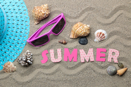 Inscription summer from paper of multi-colored letters and seashells and summer accessories on the...