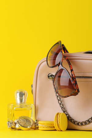 Stylish fashionable pink bag and women's cosmetics and accessories on a bright trendy yellow background. female accessory concept.の写真素材