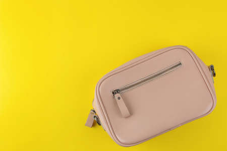 Stylish fashionable pink bag on a bright trendy yellow background. female accessory concept. top viewの写真素材