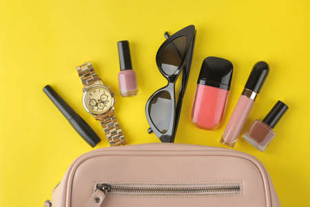 Stylish fashionable pink bag and women's cosmetics and accessories on a bright trendy yellow background. female accessory concept. top viewの写真素材