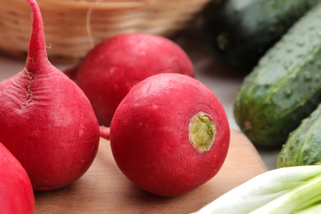 fresh radish. Spring fresh vegetables radishes, cucumber, green onions and greens on a white wooden...