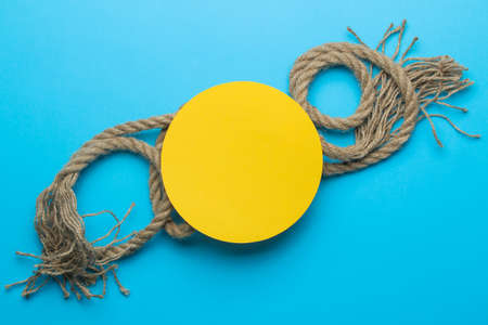 Summer frame. Paper frame for your text and marine rope on a bright light blue background. top viewの写真素材