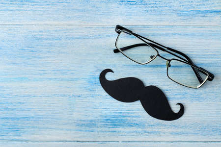 happy father's day. decorative male mustache and glasses on a light blue wooden background. top viewの写真素材