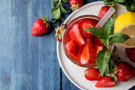 Strawberry Mojito. Cold summer mojito cocktail with strawberries, mint, lemon and ice in a glass on...