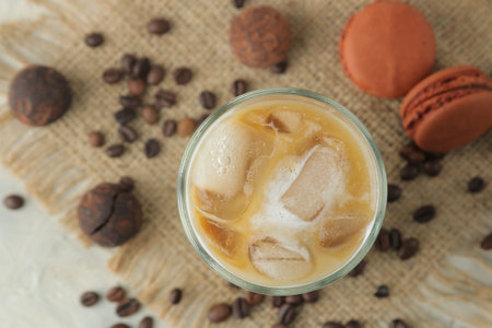 Ice latte or Iced coffee with milk and ice cubes in a glass beaker on a light background. refreshing...