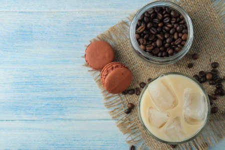 iced coffee with milk and ice cubes in a glass cup on a light blue background. refreshing drink. summer drink. top viewの写真素材