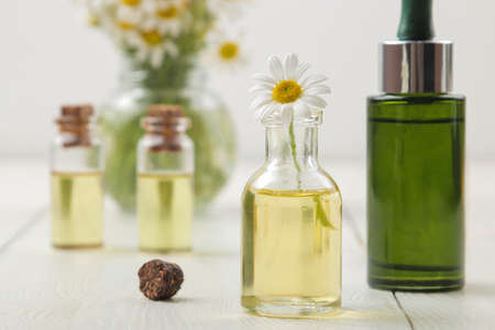 Chamomile Medicinal little flowers of chamomile with aroma oils on a white wooden table. close-upの写真素材