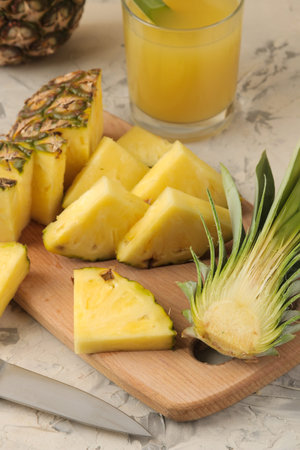 Fresh ripe pineapple halves and pineapple slices on a natural wooden background. summer. fruits.