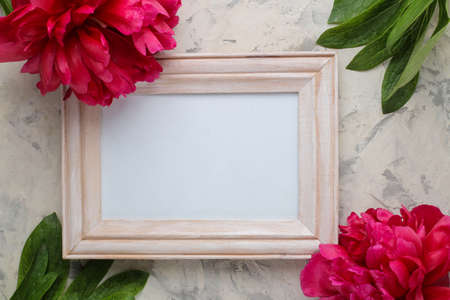 wooden Frame and Beautiful bright pink flowers peonies on a light concrete background. top view. space for textの写真素材
