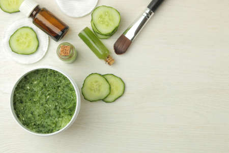 Face mask with cucumber. Cosmetics with cucumber extract on a white wooden table. spa. beauty. top viewの写真素材