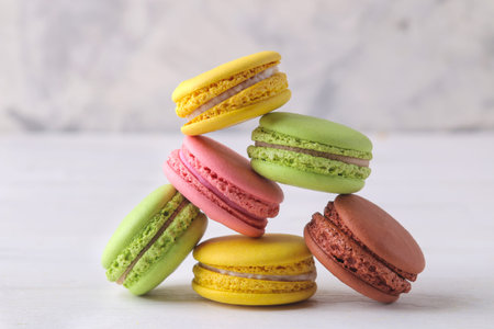 macaroons. delicious colored french macaroni cakes on a white wooden table.