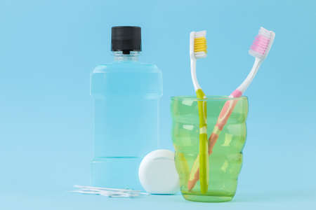 Oral hygiene. Toothbrush, dental floss and rinse for mouth and teeth on a gentle blue backgroundの写真素材