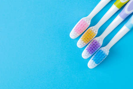 Oral hygiene. Multi-colored toothbrush on a bright blue background. place for text. top viewの写真素材