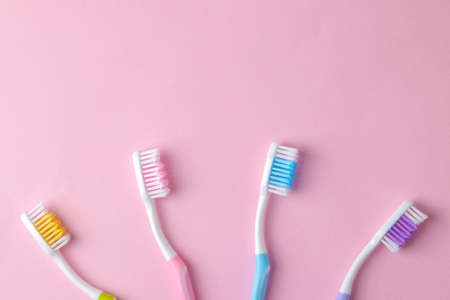 Oral hygiene. Multi-colored toothbrush on a bright pink background. top view. space for textの写真素材