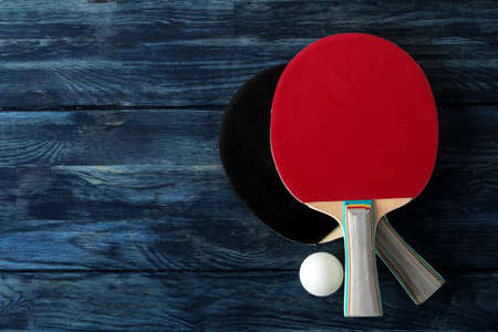 Two table tennis rackets. Table tennis rackets and a ball on a blue wooden table. sport game. top viewの写真素材
