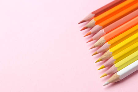 Multicolored pencils in yellow tones on a gentle trendy pink background. place for text.の写真素材