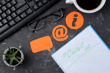 client support service. Contact us for feedback. Desktop with notepad and glasses and various...