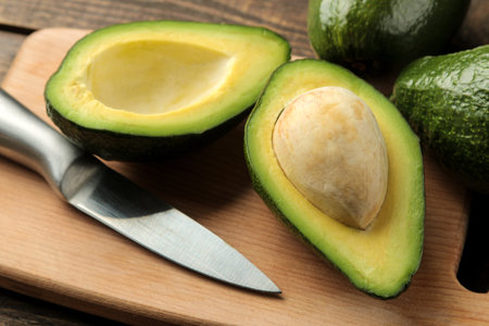 Fresh ripe tasty avocado on a cutting board on a brown wooden background. tropical fruit
