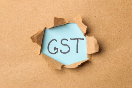 GST word and torn paper. Taxes on the background of craft paper. top view