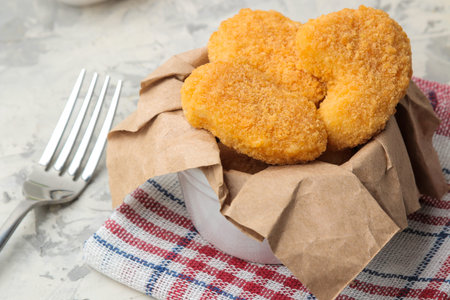 Chicken nuggets in a bowl on a light concrete table. fast food. close-up.