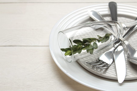 table setting. cutlery. Fork, knife, glass, spoon and plate on a white wooden table.