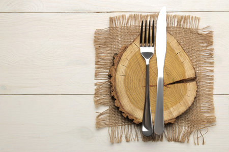 table setting. cutlery. Fork, knife and wooden stand on a white wooden table. top viewの写真素材