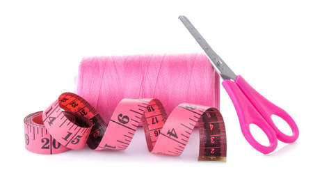 Accessories for sewing and needlework. Sewing centimeter, threads and bright scissors on a white isolated backgroundの写真素材