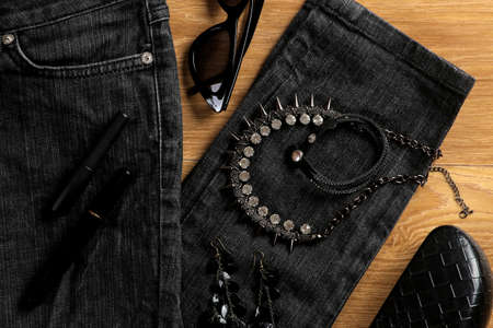 Clothes and accessories. Women's clothing and accessories in black style on a brown background. Bag, waiting, jacket. Flat lay. Top viewの写真素材