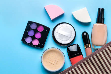 makeup kit. Women's cosmetics in a cosmetic bag. Makeup cosmetics on a bright blue background. top viewの写真素材